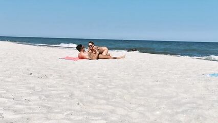 Два парня и девушка устроили групповой секс на нудистском пляже