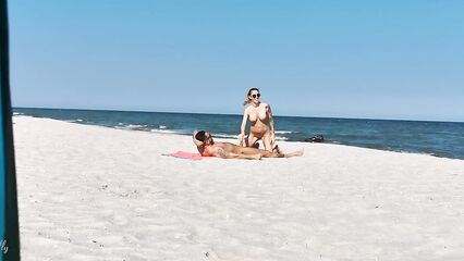 Два парня и девушка устроили групповой секс на нудистском пляже